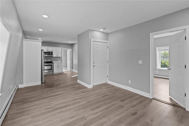 406 Cahill St, Providence, RI 02905 - unfurnished living room with a baseboard radiator, recessed lighting, and light wood-style flooring