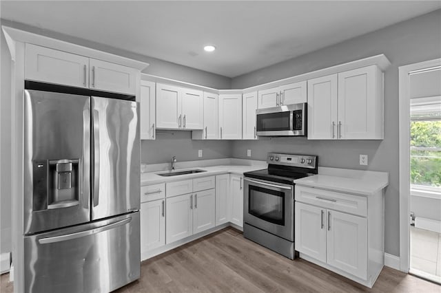 406 Cahill St, Providence, RI 02905 - kitchen with stainless steel appliances, white cabinetry, light countertops, light wood finished floors, and recessed lighting