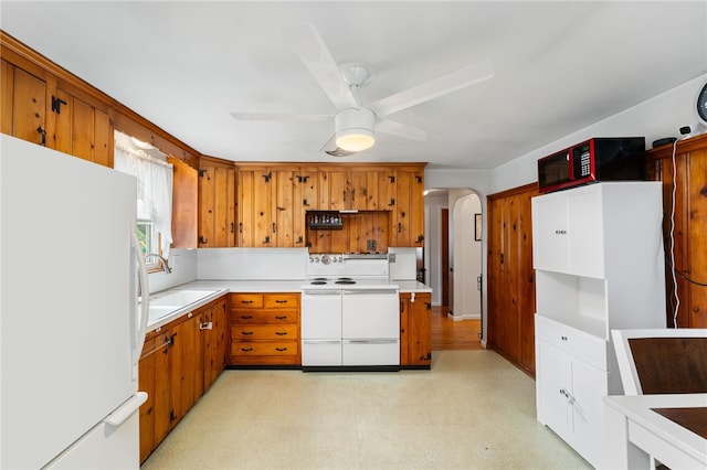2 Glen Dr, Warwick, RI 02889 - kitchen featuring white appliances, arched walkways, ceiling fan, brown cabinetry, and light countertops