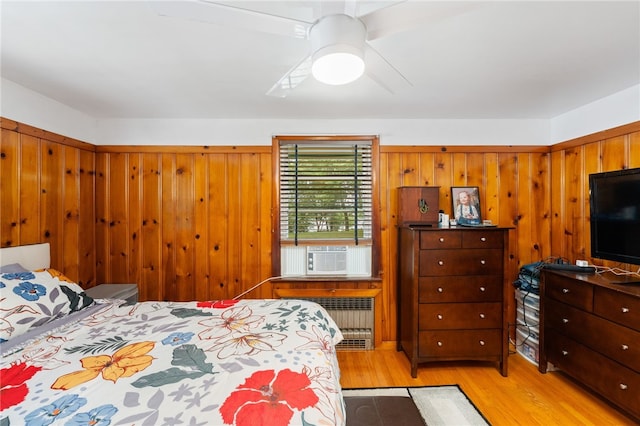 2 Glen Dr, Warwick, RI 02889 - bedroom featuring radiator heating unit, light wood-style floors, cooling unit, wooden walls, and a ceiling fan