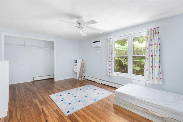 26 Pheasant Run Unit A, Smithfield, RI 02917 - bedroom featuring baseboard heating, hardwood / wood-style floors, a wall unit AC, and a closet