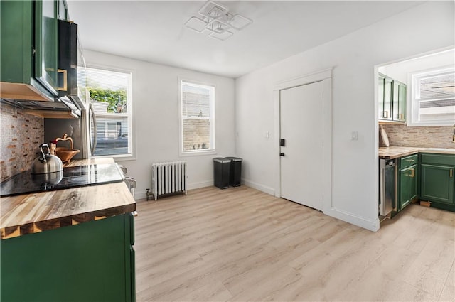 61 Wealth Ave, Providence, RI 02908 - kitchen featuring green cabinets, radiator, butcher block counters, light wood-style flooring, and tasteful backsplash