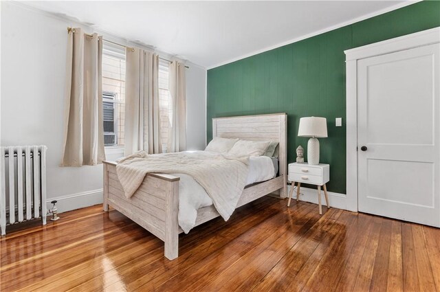61 Wealth Ave, Providence, RI 02908 - bedroom with radiator heating unit, ornamental molding, and wood finished floors