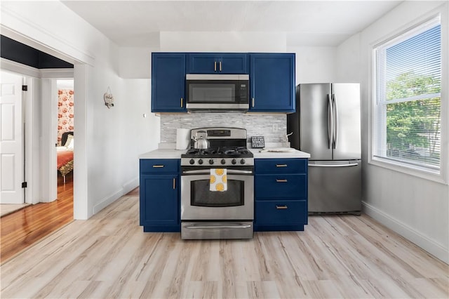 61 Wealth Ave, Providence, RI 02908 - kitchen with stainless steel appliances, blue cabinetry, light wood finished floors, and light countertops