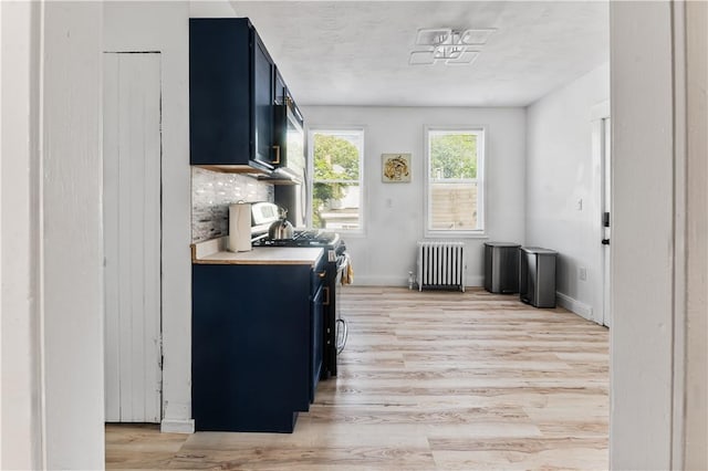 61 Wealth Ave, Providence, RI 02908 - kitchen featuring radiator heating unit, light wood-style flooring, blue cabinets, light countertops, and gas stove