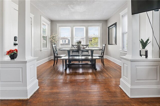 61 Wealth Ave, Providence, RI 02908 - dining area with decorative columns, dark wood-type flooring, and a textured ceiling