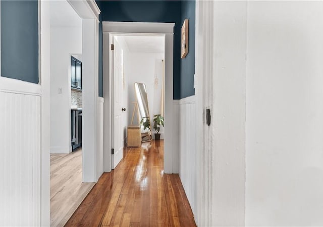 61 Wealth Ave, Providence, RI 02908 - hallway featuring a wainscoted wall, light wood finished floors, and a decorative wall