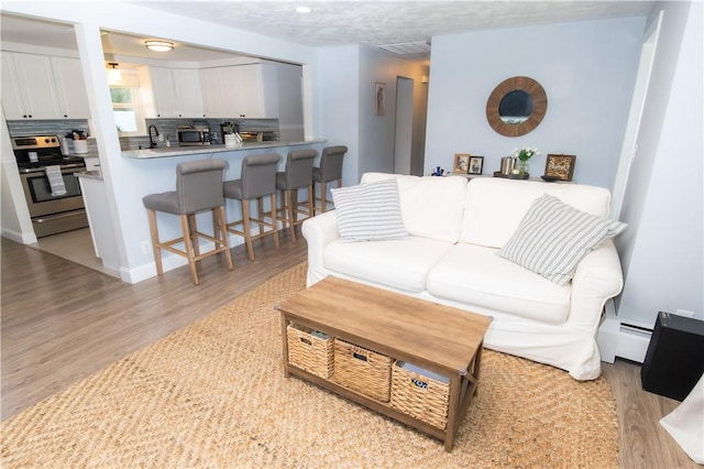 94 Osage Dr, Warwick, RI 02888 - living room featuring light wood-style flooring and a baseboard radiator