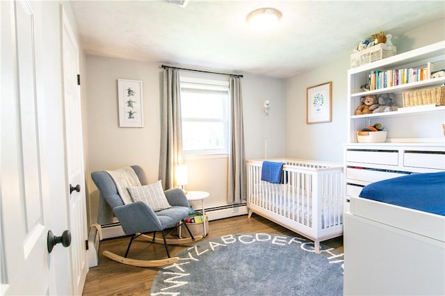 94 Osage Dr, Warwick, RI 02888 - bedroom with wood finished floors, baseboard heating, and a crib