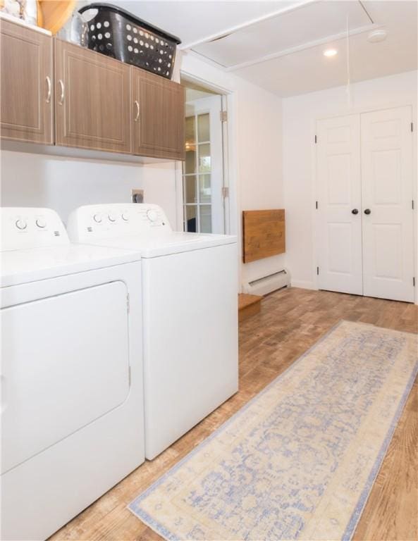 94 Osage Dr, Warwick, RI 02888 - washroom featuring cabinet space, a baseboard radiator, independent washer and dryer, attic access, and light wood-type flooring