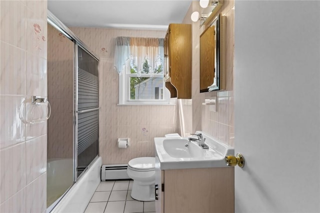 33 Limestone St, Warwick, RI 02889 - bathroom with baseboard heating, tile walls, tile patterned flooring, vanity, and enclosed tub / shower combo