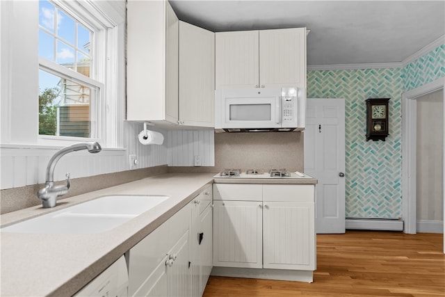 303 Washington Rd, Barrington, RI 02806 - kitchen featuring white appliances, wallpapered walls, white cabinetry, light countertops, and light wood-style floors
