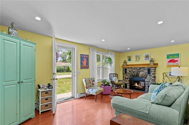 37 Ridge Rd, East Greenwich, RI 02818 - living room with a baseboard heating unit, a stone fireplace, wood finished floors, and recessed lighting