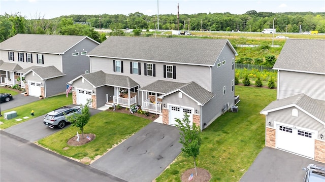 2 Sydney Rose Ct Unit B, Johnston, RI 02919 - view of front of house with covered porch, driveway, roof with shingles, stone siding, and a front yard