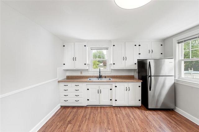 32 Rosemere Dr, East Providence, RI 02914 - kitchen with freestanding refrigerator, light wood-type flooring, white cabinets, and light countertops
