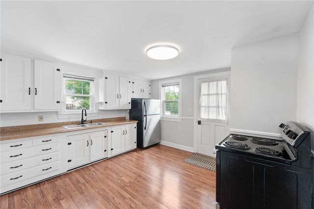 32 Rosemere Dr, East Providence, RI 02914 - kitchen featuring freestanding refrigerator, black range with electric cooktop, light wood-style floors, and plenty of natural light