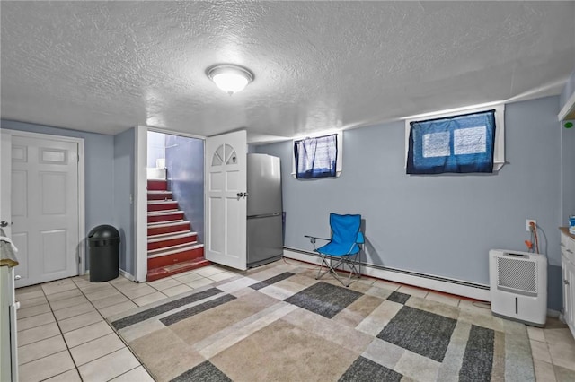 19 Covell St, Providence, RI 02909 - below grade area with a baseboard heating unit, a textured ceiling, stairway, and light tile patterned floors