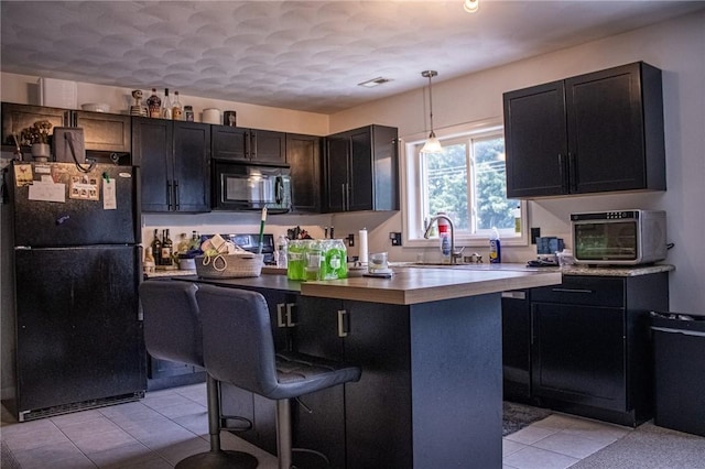 2 Main St Unit 21, Lincoln, RI 02802 - kitchen with black appliances, a breakfast bar, light tile patterned flooring, pendant lighting, and a kitchen island