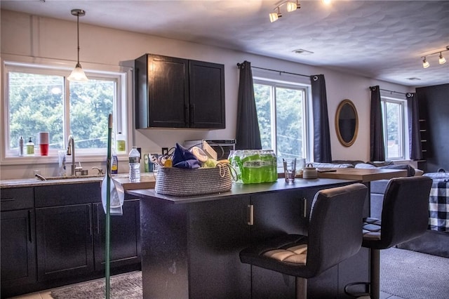 2 Main St Unit 21, Lincoln, RI 02802 - kitchen with a breakfast bar, open floor plan, track lighting, pendant lighting, and dark cabinets