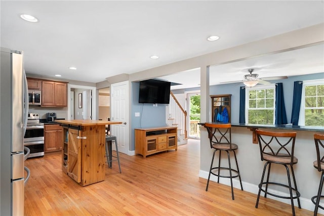 219 Fenner Hill Rd, Hopkinton, RI 02832 - kitchen featuring stainless steel appliances, a breakfast bar area, brown cabinets, light wood-style flooring, and recessed lighting