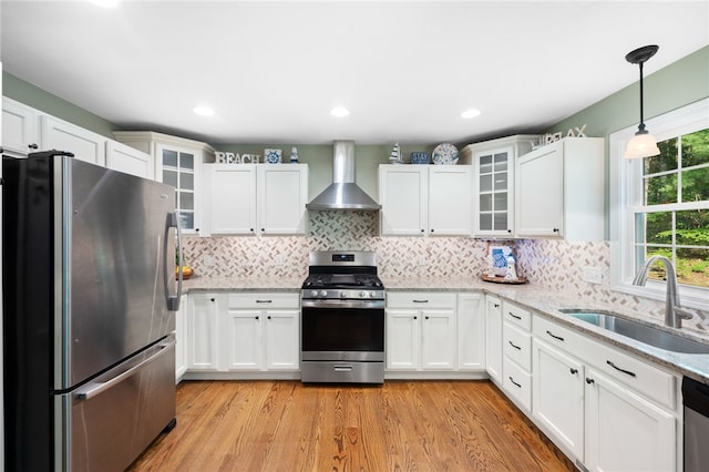 18 Country Hill Ln, Smithfield, RI 02917 - kitchen featuring appliances with stainless steel finishes, wall chimney range hood, light wood-style floors, white cabinets, and light stone countertops
