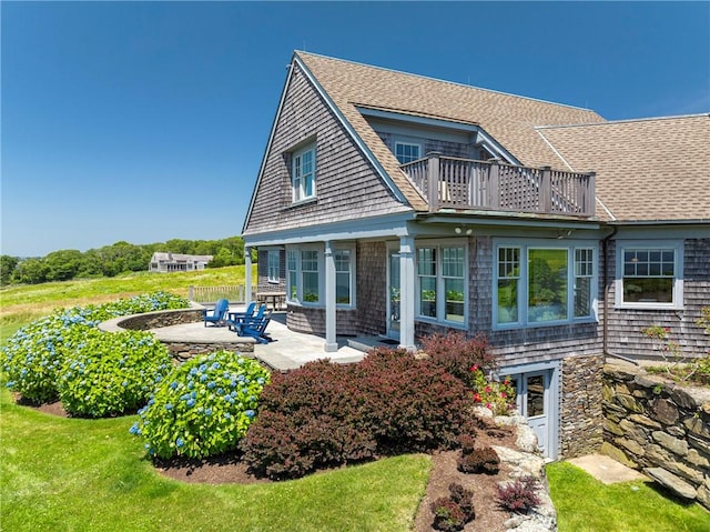 17 Ferolbink Way, Little Compton, RI 02837 - back of property featuring a balcony, a shingled roof, a patio area, and a yard