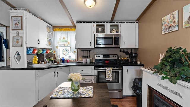 245 Manton St, Pawtucket, RI 02861 - kitchen featuring appliances with stainless steel finishes, dark countertops, white cabinets, and tasteful backsplash