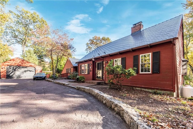 584 Division Rd, East Greenwich, RI 02818 - view of front of house featuring a chimney, an outdoor structure, a garage, and asphalt driveway