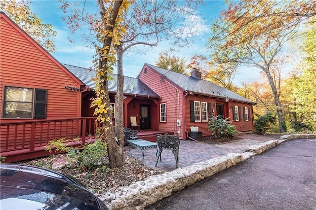 584 Division Rd, East Greenwich, RI 02818 - view of side of home with a chimney, a wooden deck, and a patio area