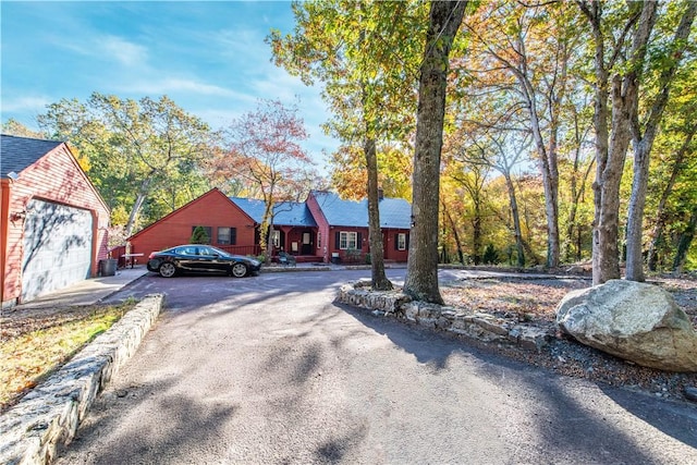 584 Division Rd, East Greenwich, RI 02818 - view of front facade with a garage, asphalt driveway, and an outbuilding
