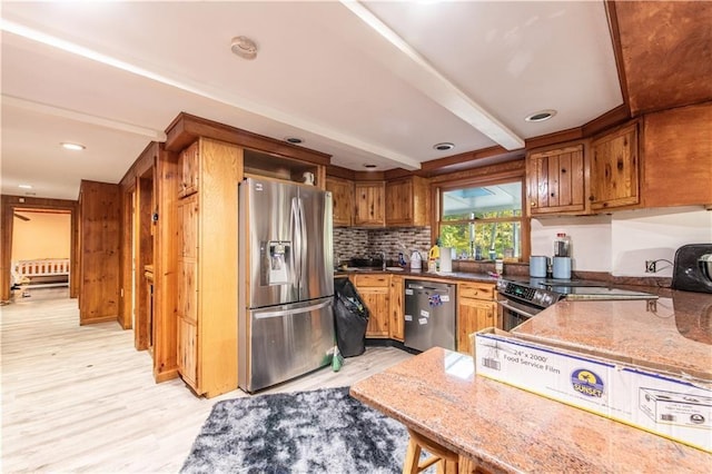 584 Division Rd, East Greenwich, RI 02818 - kitchen featuring appliances with stainless steel finishes, light wood-style flooring, brown cabinets, light stone counters, and tasteful backsplash