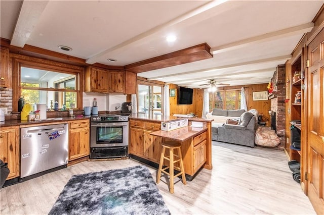 584 Division Rd, East Greenwich, RI 02818 - kitchen featuring stainless steel appliances, a peninsula, healthy amount of natural light, light wood-style floors, and beam ceiling