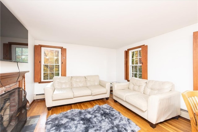 584 Division Rd, East Greenwich, RI 02818 - living area with a baseboard radiator, wood finished floors, and a brick fireplace