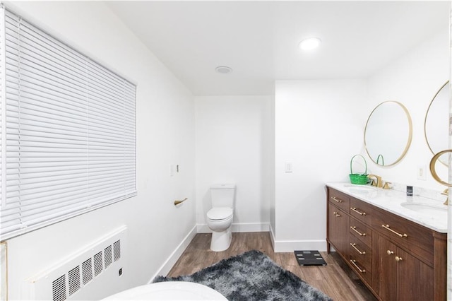584 Division Rd, East Greenwich, RI 02818 - bathroom featuring wood finished floors, double vanity, radiator, and recessed lighting