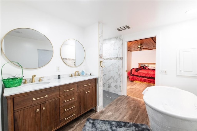 584 Division Rd, East Greenwich, RI 02818 - ensuite bathroom featuring wood finished floors, double vanity, walk in shower, and a freestanding bath