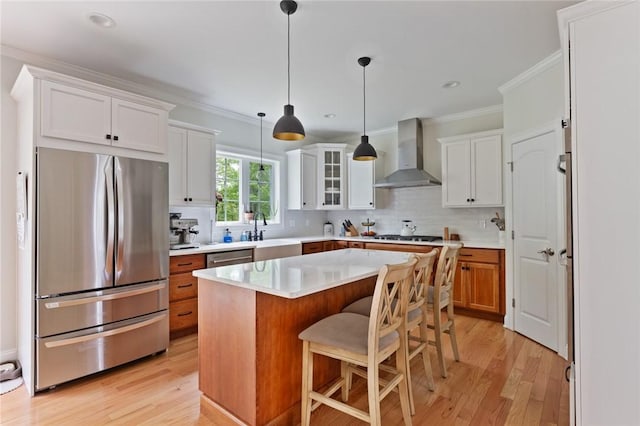 25 Kristin Dr, Cranston, RI 02921 - kitchen with appliances with stainless steel finishes, wall chimney range hood, ornamental molding, light wood-style floors, and backsplash