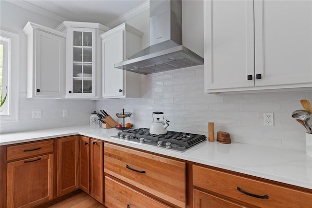 25 Kristin Dr, Cranston, RI 02921 - kitchen with wall chimney range hood, stainless steel gas cooktop, decorative backsplash, white cabinetry, and ornamental molding