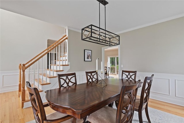 25 Kristin Dr, Cranston, RI 02921 - dining space featuring light wood-style floors, ornamental molding, a decorative wall, stairway, and a wainscoted wall