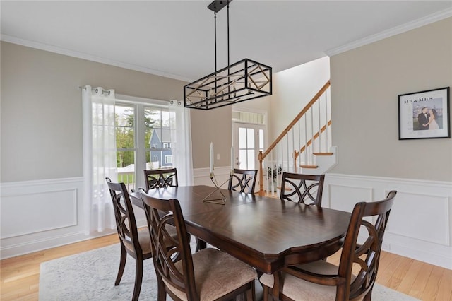 25 Kristin Dr, Cranston, RI 02921 - dining room featuring ornamental molding, light wood finished floors, wainscoting, a decorative wall, and a chandelier