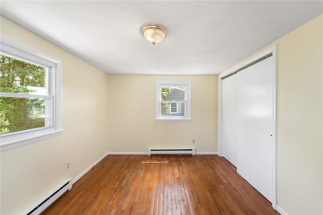 19 Cantara St, West Warwick, RI 02893 - unfurnished bedroom with baseboard heating, a baseboard heating unit, wood-type flooring, and a closet