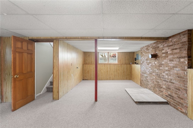 19 Cantara St, West Warwick, RI 02893 - basement featuring a paneled ceiling, carpet, wood walls, stairs, and brick wall