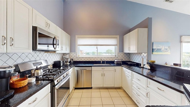 4090 Post Rd Unit B, Warwick, RI 02886 - kitchen featuring appliances with stainless steel finishes, light tile patterned flooring, backsplash, white cabinets, and dark stone counters