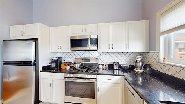 4090 Post Rd Unit B, Warwick, RI 02886 - kitchen featuring stainless steel appliances, tasteful backsplash, white cabinetry, and dark stone countertops