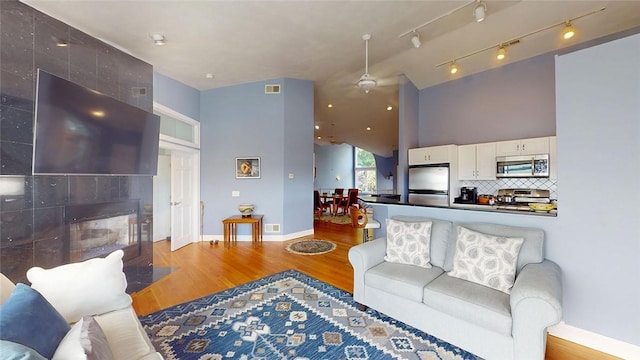 4090 Post Rd Unit B, Warwick, RI 02886 - living room with wood finished floors, a tiled fireplace, and a high ceiling