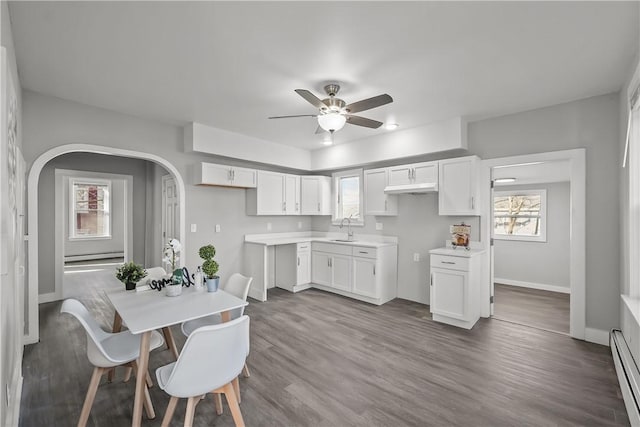 40 Jenkins St, Providence, RI 02906 - kitchen featuring a baseboard heating unit, white cabinetry, a ceiling fan, a baseboard radiator, and arched walkways