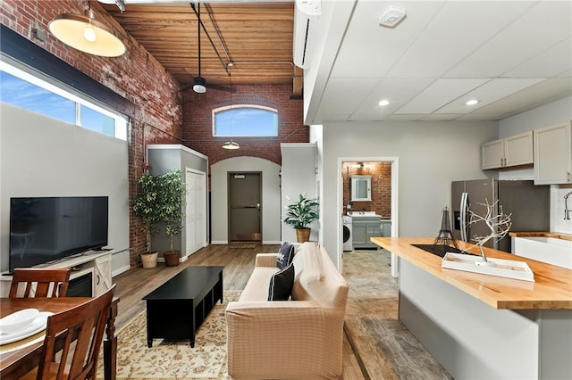 1117 Douglas Ave Unit 124, North Providence, RI 02904 - living room with brick wall, light wood-type flooring, a high ceiling, and recessed lighting
