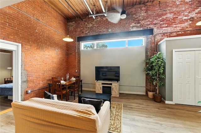 1117 Douglas Ave Unit 124, North Providence, RI 02904 - living area with a towering ceiling, brick wall, wood finished floors, and wooden ceiling