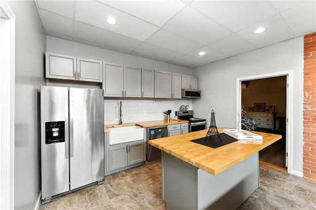 1117 Douglas Ave Unit 124, North Providence, RI 02904 - kitchen featuring appliances with stainless steel finishes, wooden counters, gray cabinetry, a paneled ceiling, and brick wall