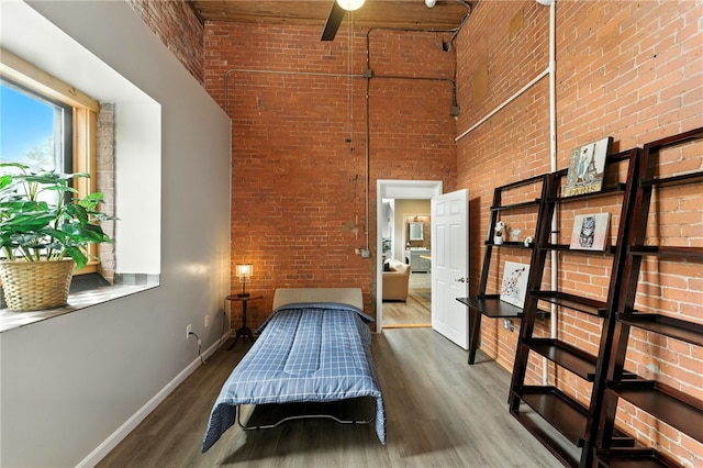 1117 Douglas Ave Unit 124, North Providence, RI 02904 - bedroom featuring a high ceiling, wood finished floors, and brick wall