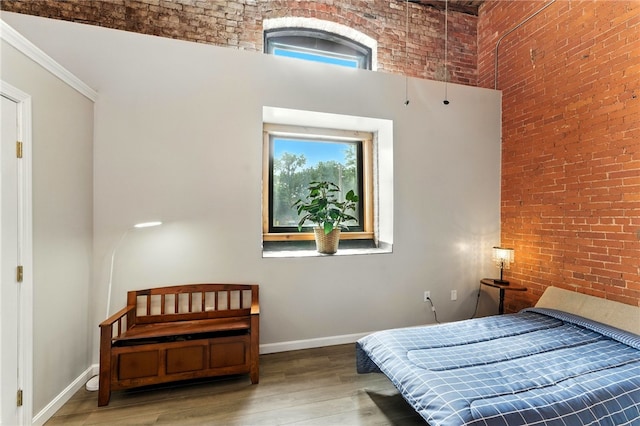 1117 Douglas Ave Unit 124, North Providence, RI 02904 - bedroom with a high ceiling, wood finished floors, multiple windows, and brick wall
